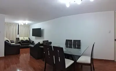 a living room with a glass table and black chairs at CasaBlanca2 in Lima