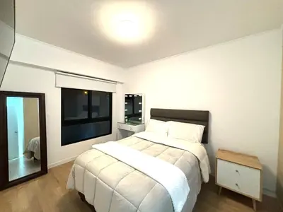 a bedroom with a large white bed and a mirror at Bello y amplio apartamento, en la mejor zona de Barranco in Lima