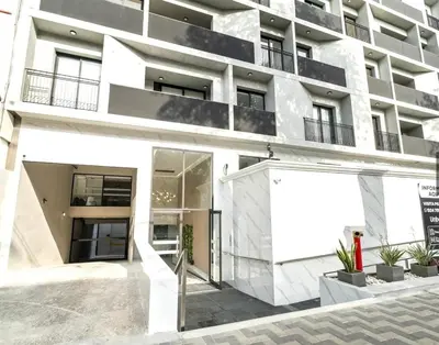 a white apartment building with a sign in front of it at Bello y amplio apartamento, en la mejor zona de Barranco in Lima