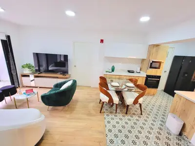 a living room with a table and chairs and a kitchen at Bello y amplio apartamento, en la mejor zona de Barranco in Lima