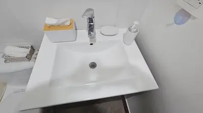a white sink in a bathroom with a toilet at Departamento con Increíble ubicación en San Miguel in Lima