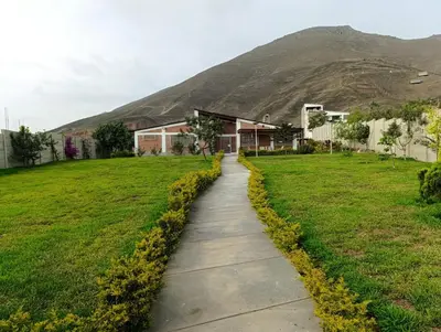 a path through a field with a mountain in the background at Country house in Pachacamac in Lima