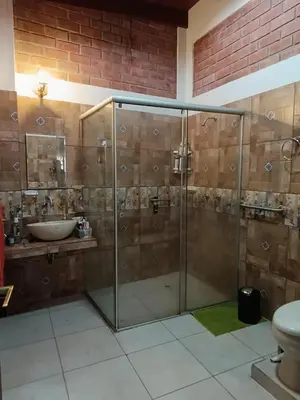 a bathroom with a glass shower and a sink at Country house in Pachacamac in Lima