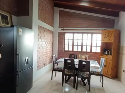 a kitchen with a table and chairs and a refrigerator at Country house in Pachacamac in Lima