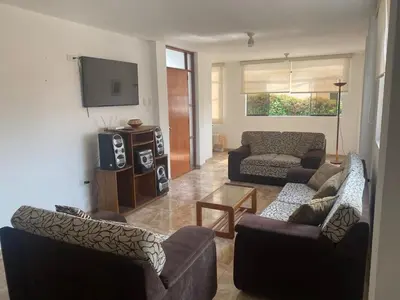 a living room with two couches and a tv at Departamento cerca a Cerro Azul in Hualcará