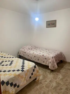 a room with two beds and a picture on the wall at Departamento cerca a Cerro Azul in Hualcará