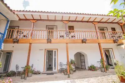 a building with a balcony and tables and chairs at QOSQO BELVEDERE, apartamento en Cuesta San Blas in Cusco