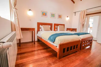 a bedroom with a bed and a wooden floor at QOSQO BELVEDERE, apartamento en Cuesta San Blas in Cusco