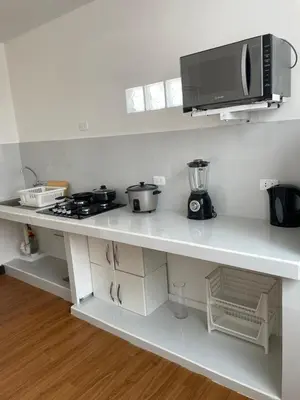 a kitchen counter with a stove and a microwave at Lindo departamento muy cerca a la playa in Punta Negra