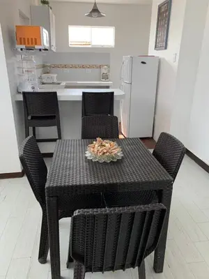 a kitchen with a table with chairs and a refrigerator at Mini Dpto frente al mar playa Pta N in Punta Negra