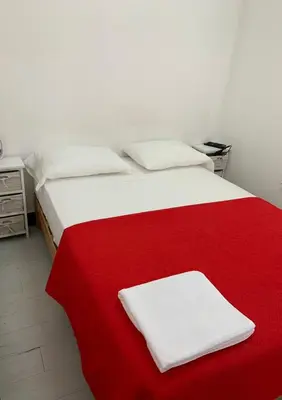 a white and red bed with two towels on it at Mini Dpto frente al mar playa Pta N in Punta Negra