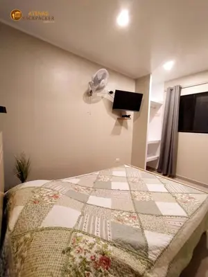 a bedroom with a bed with a fan and a television at Atenas Backpacker Hospedaje in Paracas