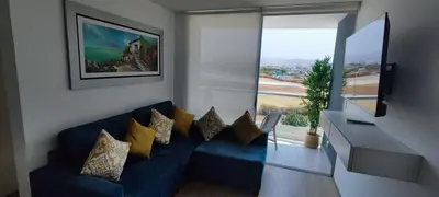a living room with a blue couch and a window at Apartamento San Bartolo in San Bartolo