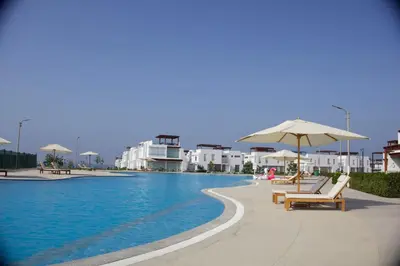 a swimming pool with chairs and umbrellas and buildings at Casa de Playa - Asia - SELENE beach house in Asia