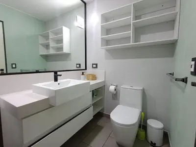 a white bathroom with a toilet and a sink at Apartment in San Isidro in Lima