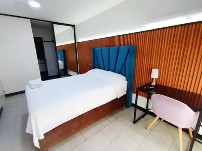 a bedroom with a bed and a table and a chair at Apartment in San Isidro in Lima