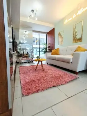 a living room with a white couch and a pink rug at 2BR Deluxe Apartment in San Isidro in Lima