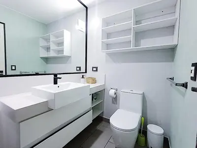 a white bathroom with a toilet and a sink at 2BR Deluxe Apartment in San Isidro in Lima