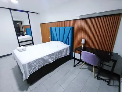 a bedroom with a bed and a desk and a mirror at 2BR Deluxe Apartment in San Isidro in Lima