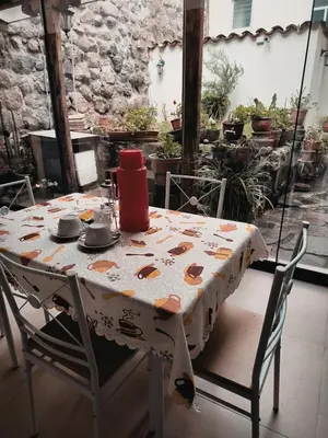 a table with a table cloth on it with chairs at Departamento 2 Waynapata Centro Historico Cusco in Cusco