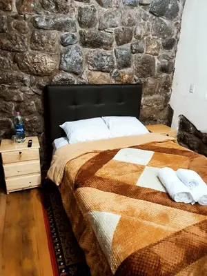 a bedroom with a bed and a stone wall at Departamento 2 Waynapata Centro Historico Cusco in Cusco