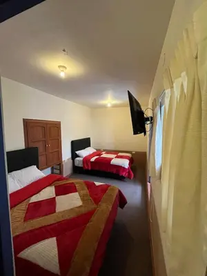 a bedroom with two beds and a tv in it at Departamento 2 Waynapata Centro Historico Cusco in Cusco