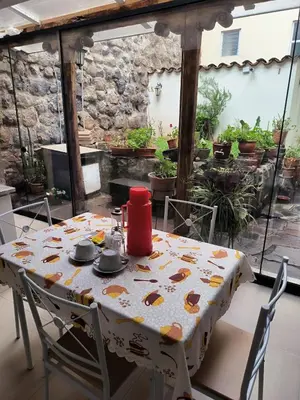 a table and chairs on a patio with a tablecloth on it at Departamento 2 Waynapata Centro Historico Cusco in Cusco