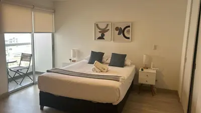 a bedroom with a bed and a table with a chair at Inca inn apartments in Lima