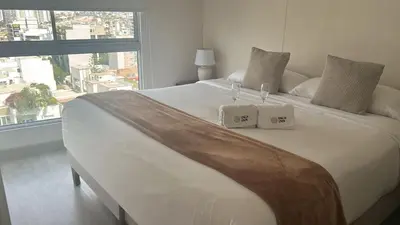 a bedroom with a large bed with two boxes on it at Inca inn apartments in Lima