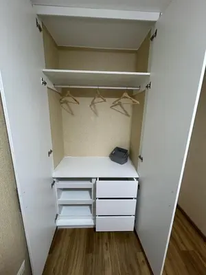 a walk in closet with white cabinets and hangers at Luxury apartment with panoramic view of San Isidro in Lima