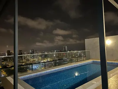 a swimming pool on the roof of a building at night at Luxury apartment with panoramic view of San Isidro in Lima