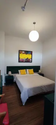 a bedroom with a large white bed with yellow pillows at Flying Dog Hostel in Lima