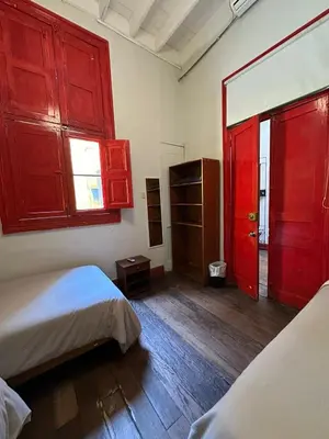 a room with two beds and red cabinets and a mirror at Flying Dog Hostel in Lima