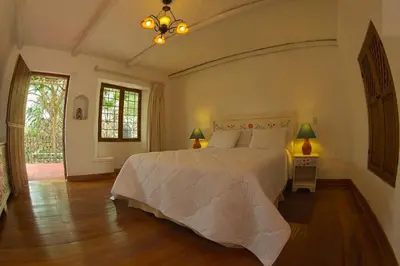 a bedroom with a large white bed and a window at Hotel Rustica Lunahuana in Uchupampa