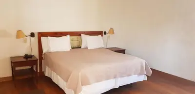 a bedroom with a bed with two night stands and two lamps at Hotel Rustica Lunahuana in Uchupampa