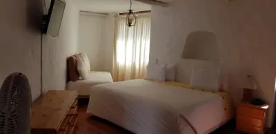 a hotel room with two beds and a window at Hotel Rustica Lunahuana in Uchupampa