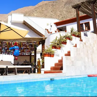 a villa with a swimming pool and a house at Hotel Rustica Lunahuana in Uchupampa
