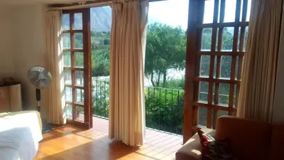 a living room with doors open to a balcony at Hotel Rustica Lunahuana in Uchupampa