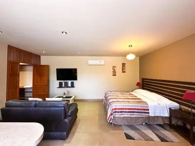 a bedroom with a bed and a couch at Apart-Hotel El Cañaveral in Chincha