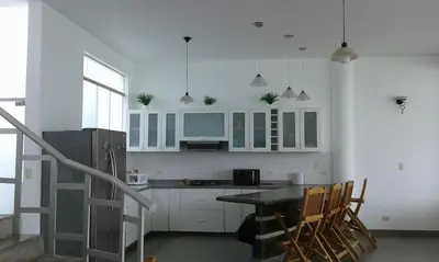 a kitchen with white cabinets and a table and chairs at ESCAPA DE LA RUTINA Y DISFRUTA Asia - Chocaya in Asia