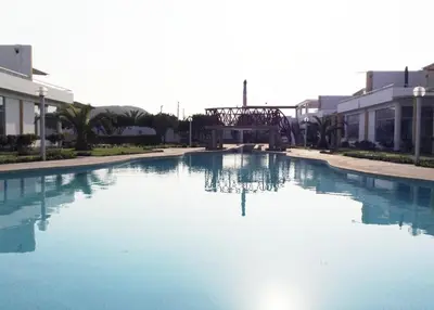a large pool of blue water in front of buildings at ESCAPA DE LA RUTINA Y DISFRUTA Asia - Chocaya in Asia