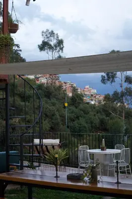 a patio with a table and chairs and a view of a city at Casa Campestre on the side of Saqsaywaman in Cusco