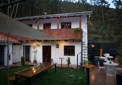 a house with a wooden table in the yard at Casa Campestre on the side of Saqsaywaman in Cusco