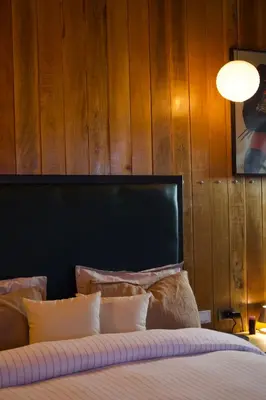 a bedroom with a bed with a wooden wall at Mountain lodge with Spectacular View in Cusco