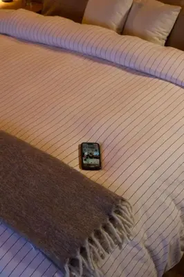 a bed with a remote control on top of it at Mountain lodge with Spectacular View in Cusco
