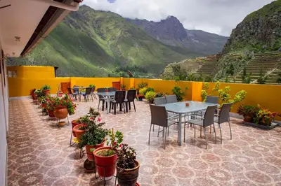a patio with tables and chairs and potted plants at Intitambo Hotel in Ollantaytambo