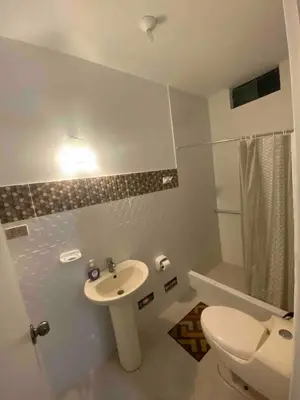 a white bathroom with a sink and a toilet at Chinchacampoymar Casa de playa en Chincha in Chincha Baja