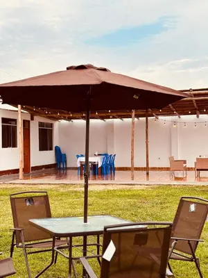 a table and chairs under an umbrella in a yard at Casa Puente Azul - Casa de Playa in Cerro Azul
