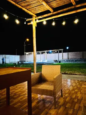 a patio with a table and a chair and a tennis court at Casa Puente Azul - Casa de Playa in Cerro Azul