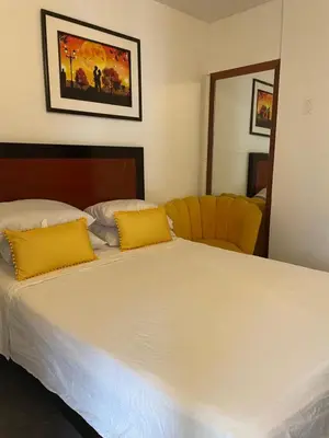 a bedroom with a large white bed with yellow pillows at Departamento mejor sector de Ica in Ica